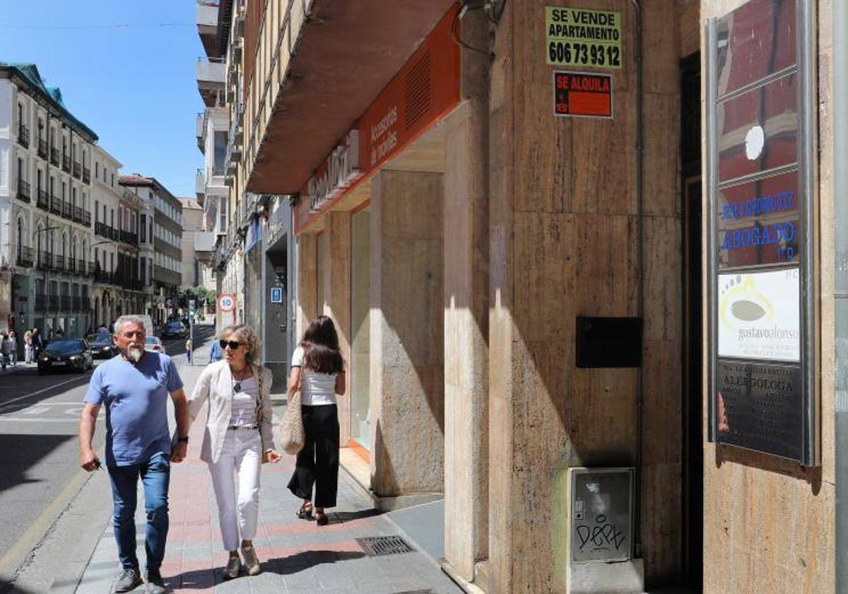 Carteles de venta y alquiler de pisos en un bloque de Palencia.