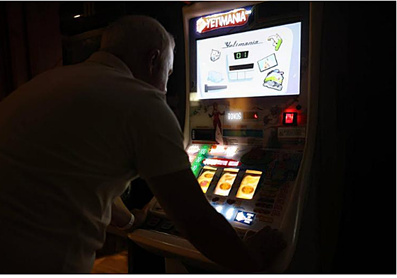 Un joven juega a una máquina tragaperras.