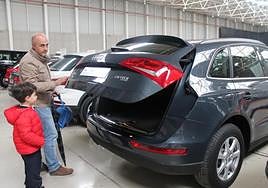 Un hombre y su hijo examinan un coche de segunda mano.