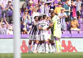 Los jugadores del Real Valladolid celebran el gol frente al Mirandés abrazados, con los aficionados aplaudiendo de fondo.