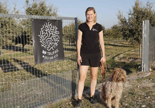 Raquel con su perro Lucas, experto en buscar trufas, en su plantación de encinas