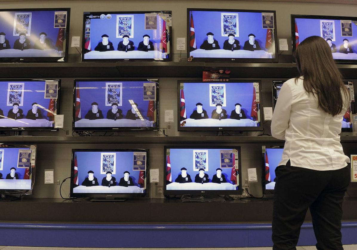 Una mujer observa en televisión la lectura del comunicado de ETA anunciando el cese definitivo de su actividad armada en octubre de 2011.