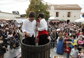 Los niños Jesús Rodríguez y Hugo Medrano realizan el tradicional pisado de la uva.