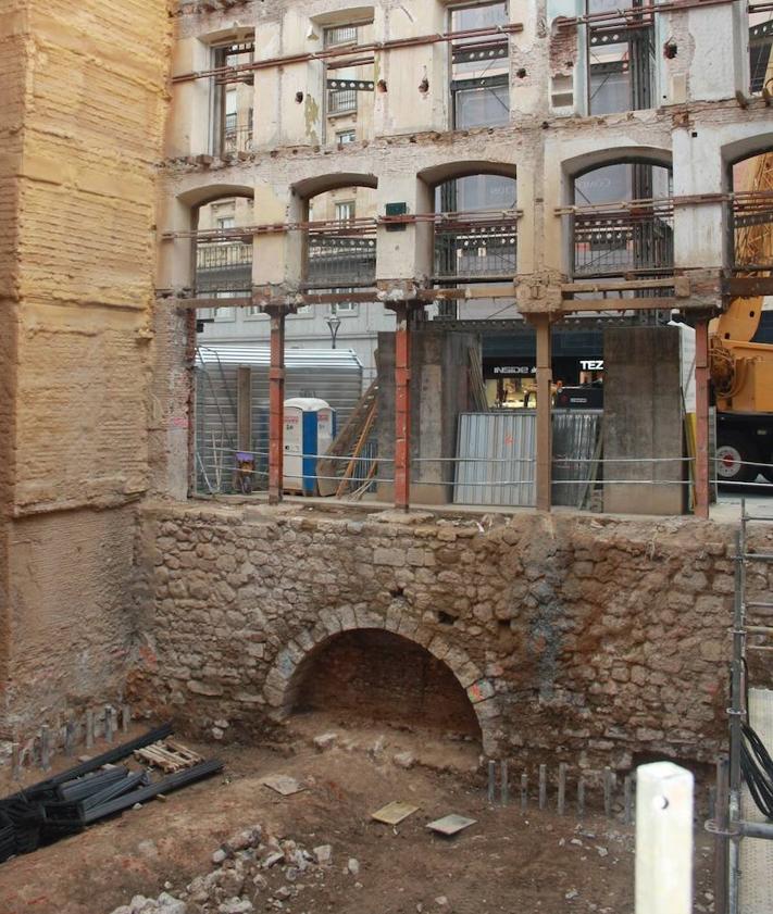 Imagen secundaria 2 - Arriba, adoquinado que marca la presencia del puente del Esgueva en la calle Santiago. Debajo, a la izquierda, interior del puente de la Puerta del Campo y (derecha) el ojo al descubierto del mismo.