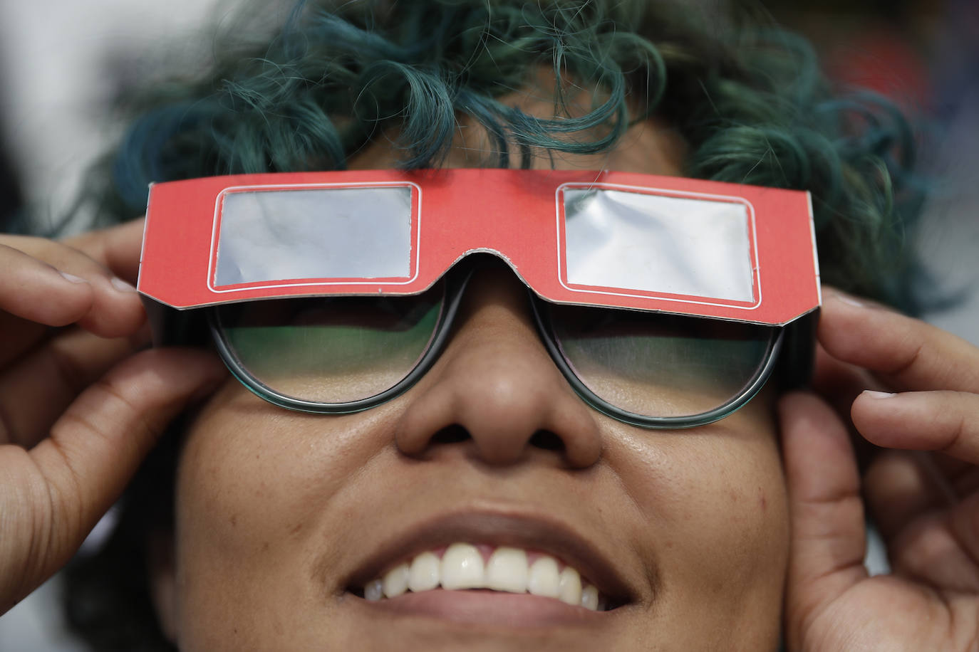 Una mujer mira hoy el eclipse solar desde el observatorio de la Universidad Don Bosco, en Soyapango (El Salvador). 