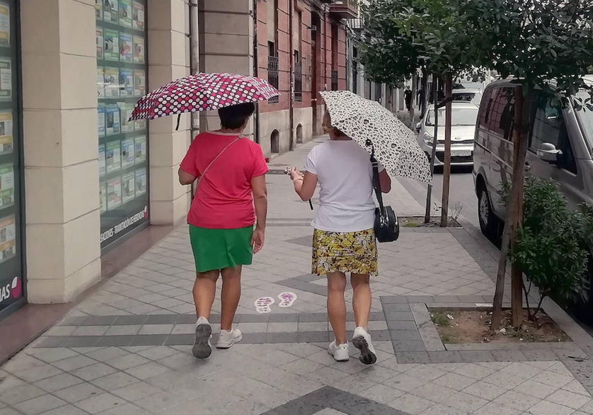 Viandantes con paraguas en la calle Panaderos.