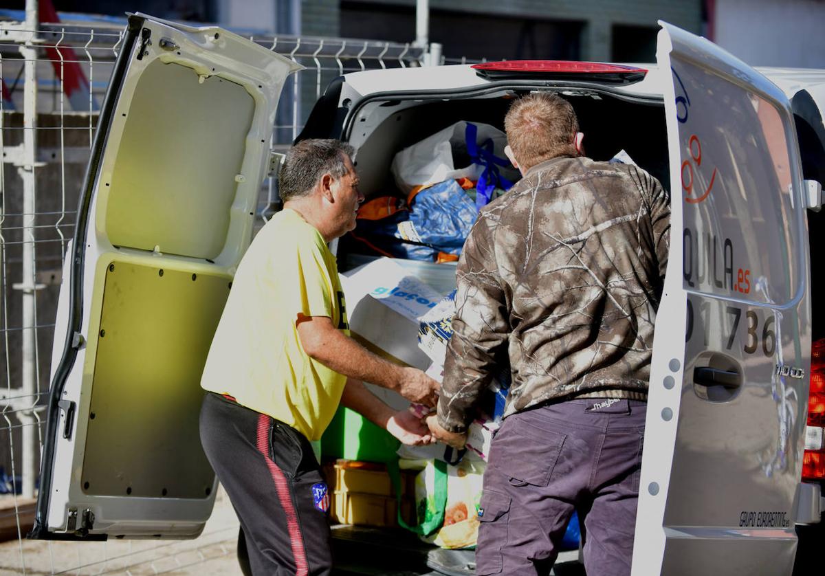 Un vecino coloca sus enseres en una furgoneta para trasladarlos a su nueva vivienda.