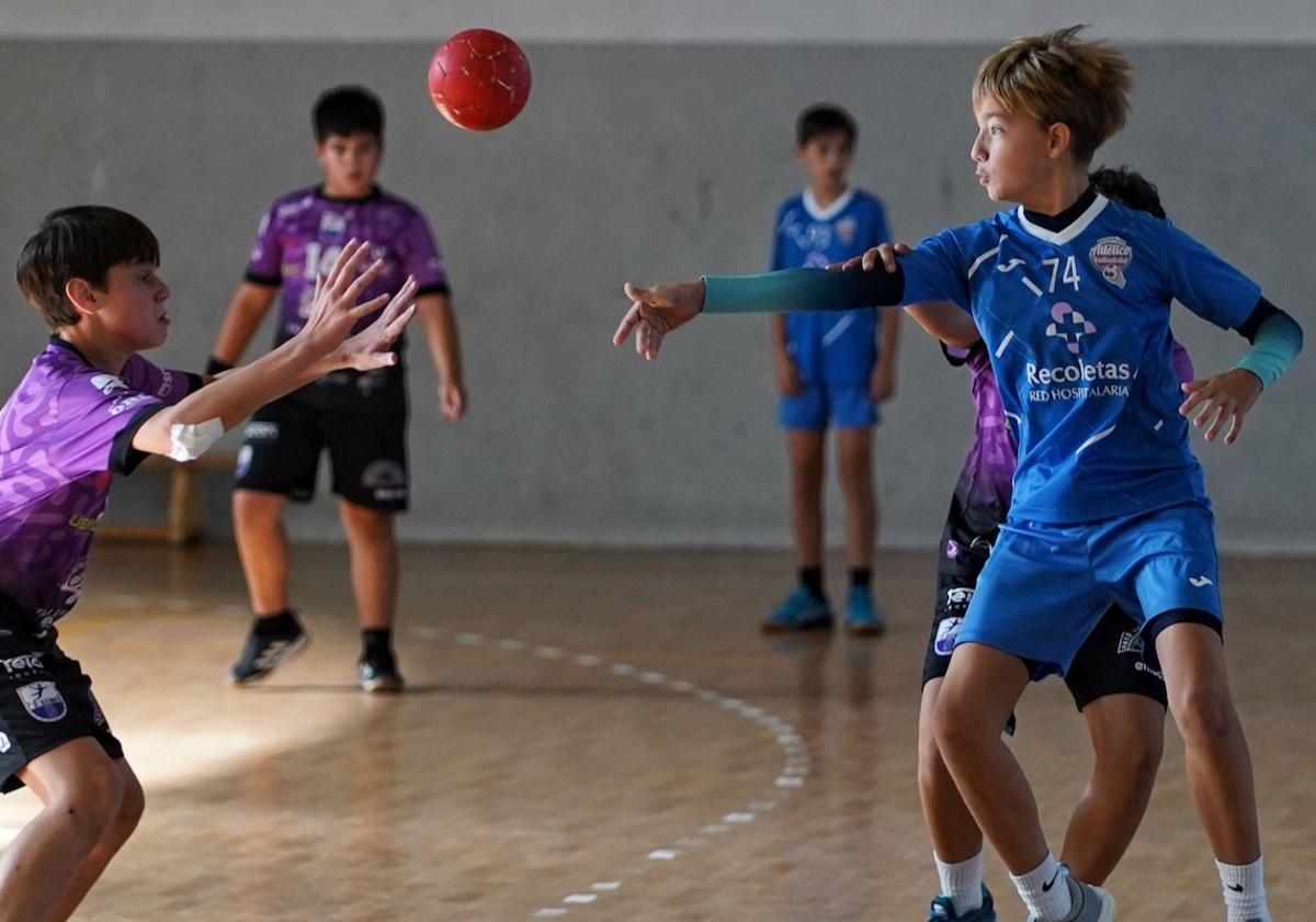 El canterano del Recoletas pasa el balón delante del defensa rival.