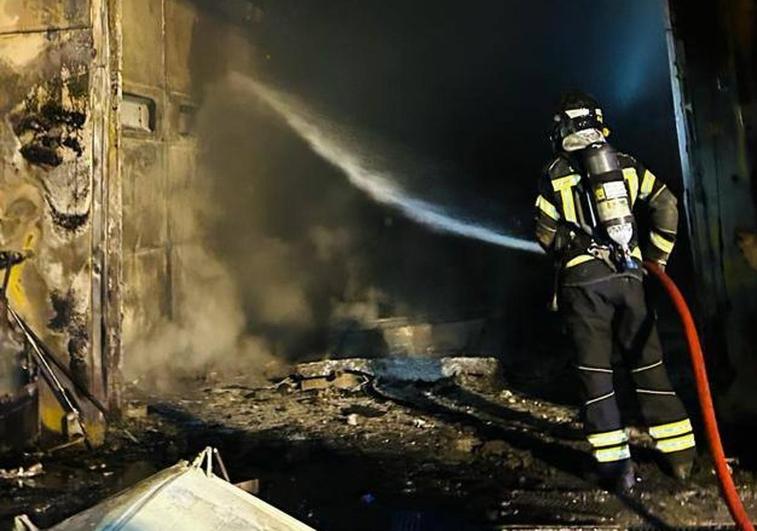 Un bombero trabaja en la extinción de las llamas en una zona de la fábrica Granalu.