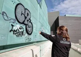 Una vigilante del museo muestra el grafiti realizado en la fachada.