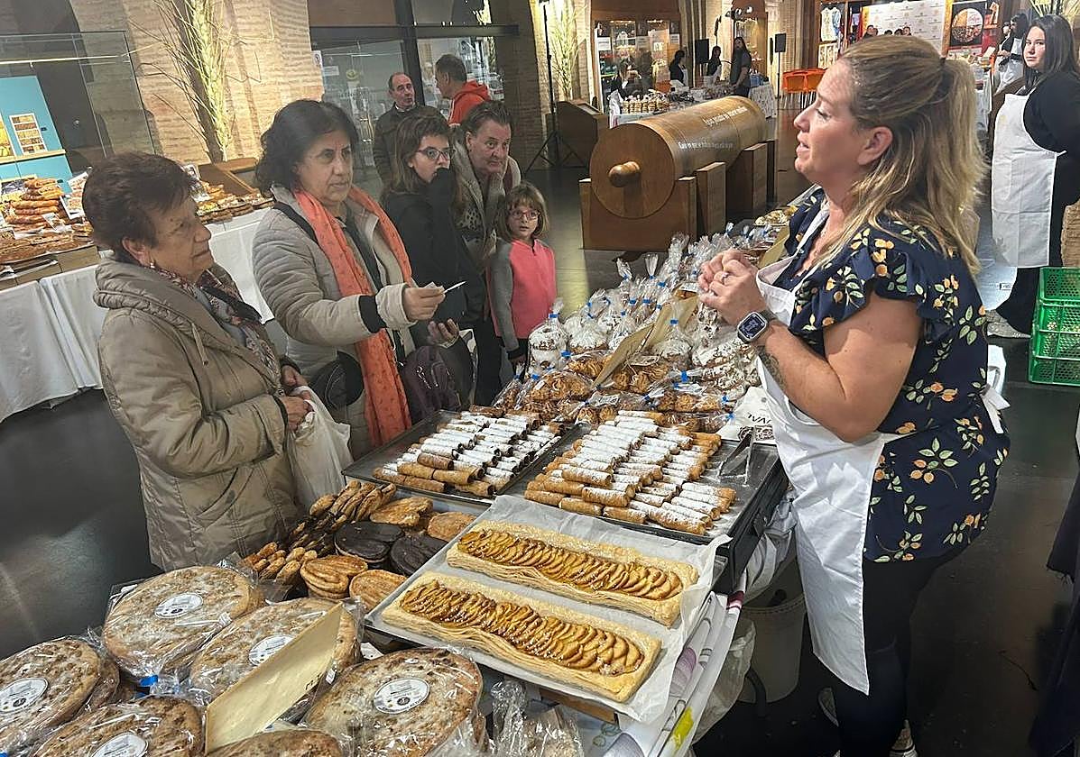 Una mujer atiende a los visitantes en uno de los puestos de la feria.