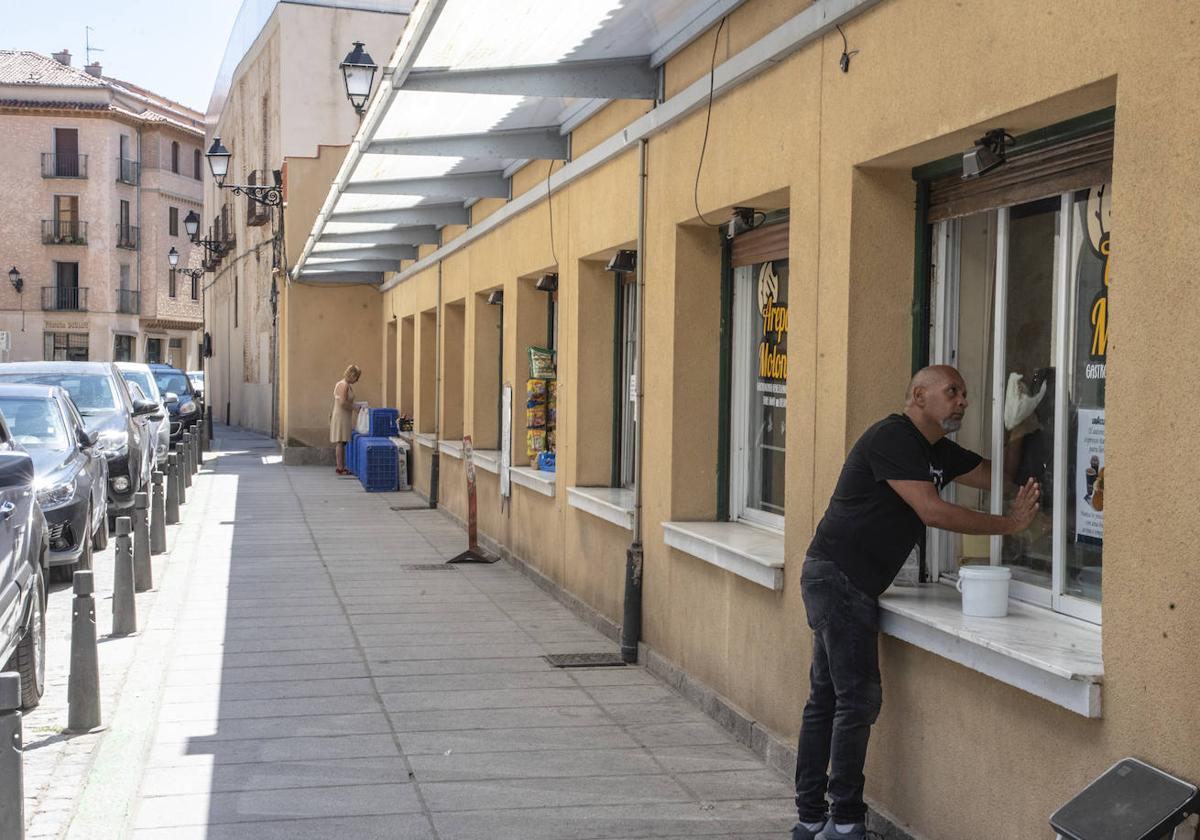 Un hombre, frente a un comercio del mercado de Los Huertos.