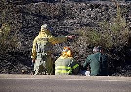 Un agente forestal, junto a otros compañeros, tras extinguir un incendio en León este verano.