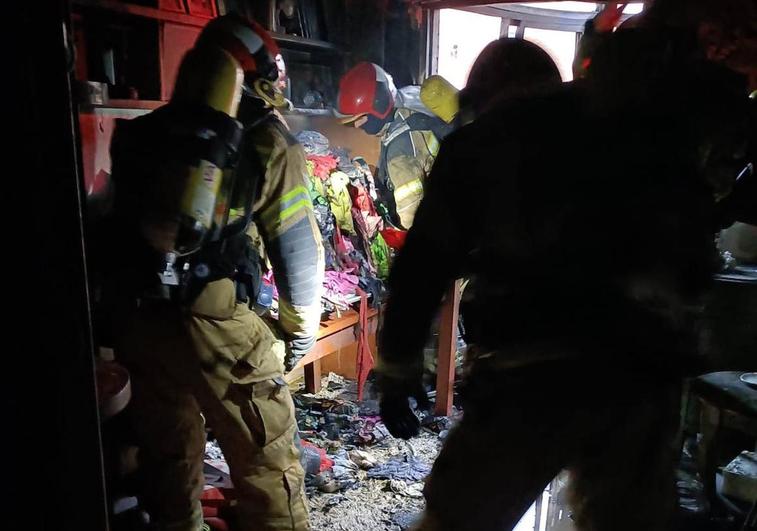 Bomberos en el interior de la vivienda siniestrada.