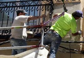 Dos hombres trabajan en la rehabilitación de un edificio en Segovia.