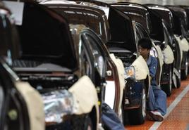 Varios operarios trabajan en una cadena de montaje Geely Motors, en Cixi (China).