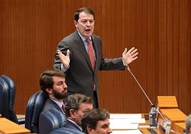 Alfonso Fernández Mañueco se ajusta el nudo de la corbata antes de empezar a contestar a los portavoces de la oposición en el pleno de las Cortes.