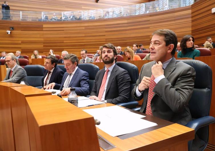 Alfonso Fernández Mañueco se ajusta el nudo de la corbata antes de empezar a contestar a los portavoces de la oposición en el pleno de las Cortes.