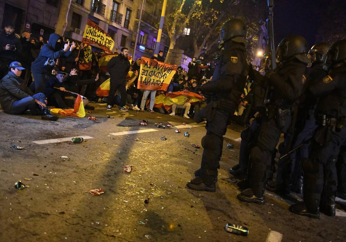 Decenas de manifestantes con banderas se enfrentan a la Policía, en la sede del PSOE en la calle Ferraz de Madrid.