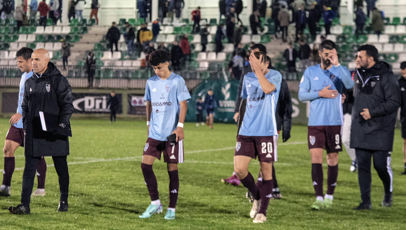 Jugadores de la Segoviana abandonan el terreno de juego con gestos de desilusión.