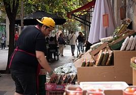 Un dependiente coloca fruta en un expositor exterior en una imagen de archivo.