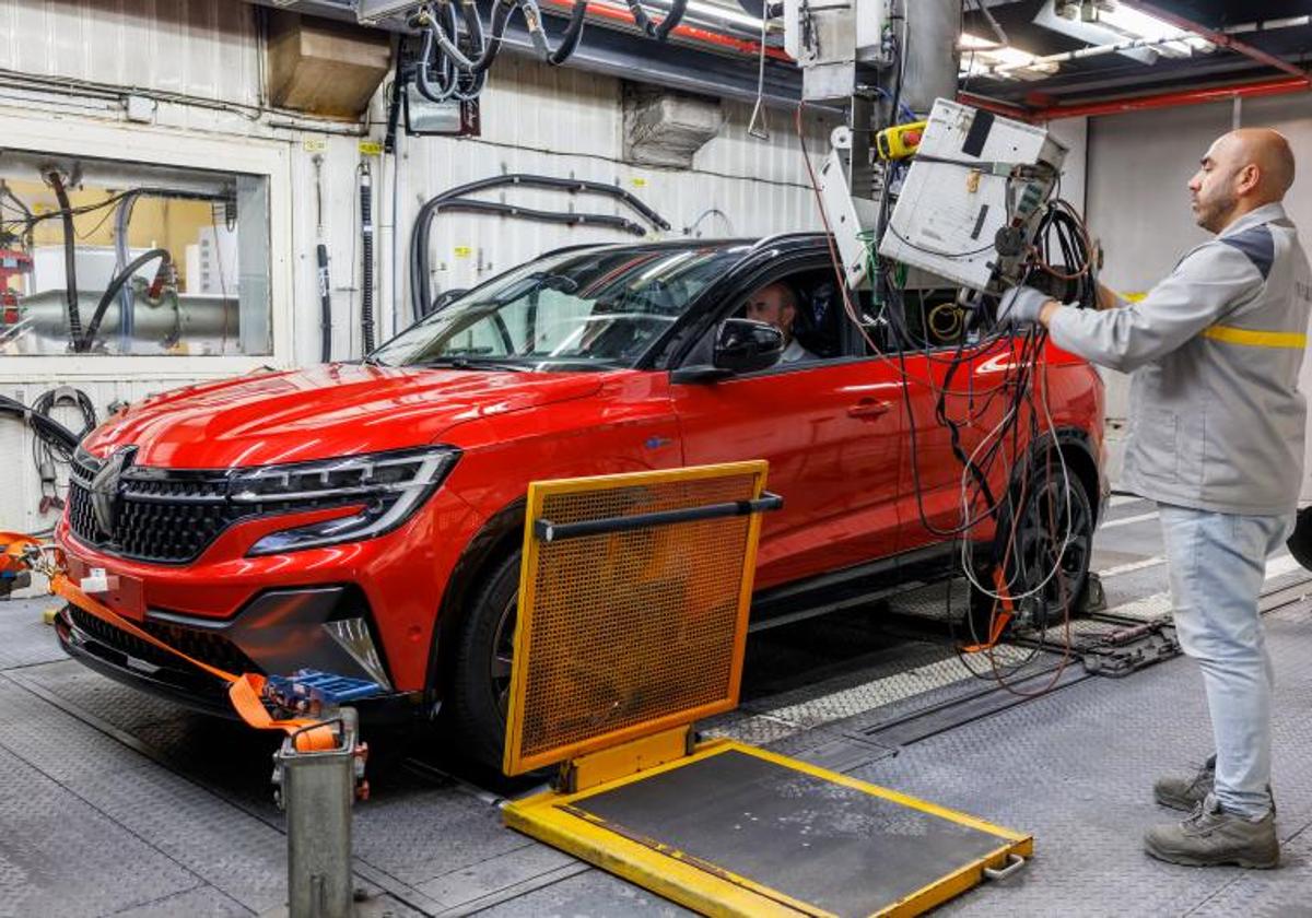 Dos trabajadores en la Factoría de Renault de Villamuriel de Cerrato (Palencia) con un modelo Austral.