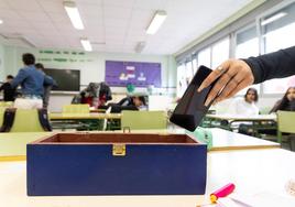 Alumnos de un instituto de Valladolid depositan sus móviles en una caja antes de empezar la clase.