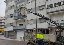 Operarios instalan las luminarias en un calle de Cuéllar.