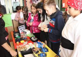 Un grupo de niños compran productos solidarios en el mercadillo benéfico.