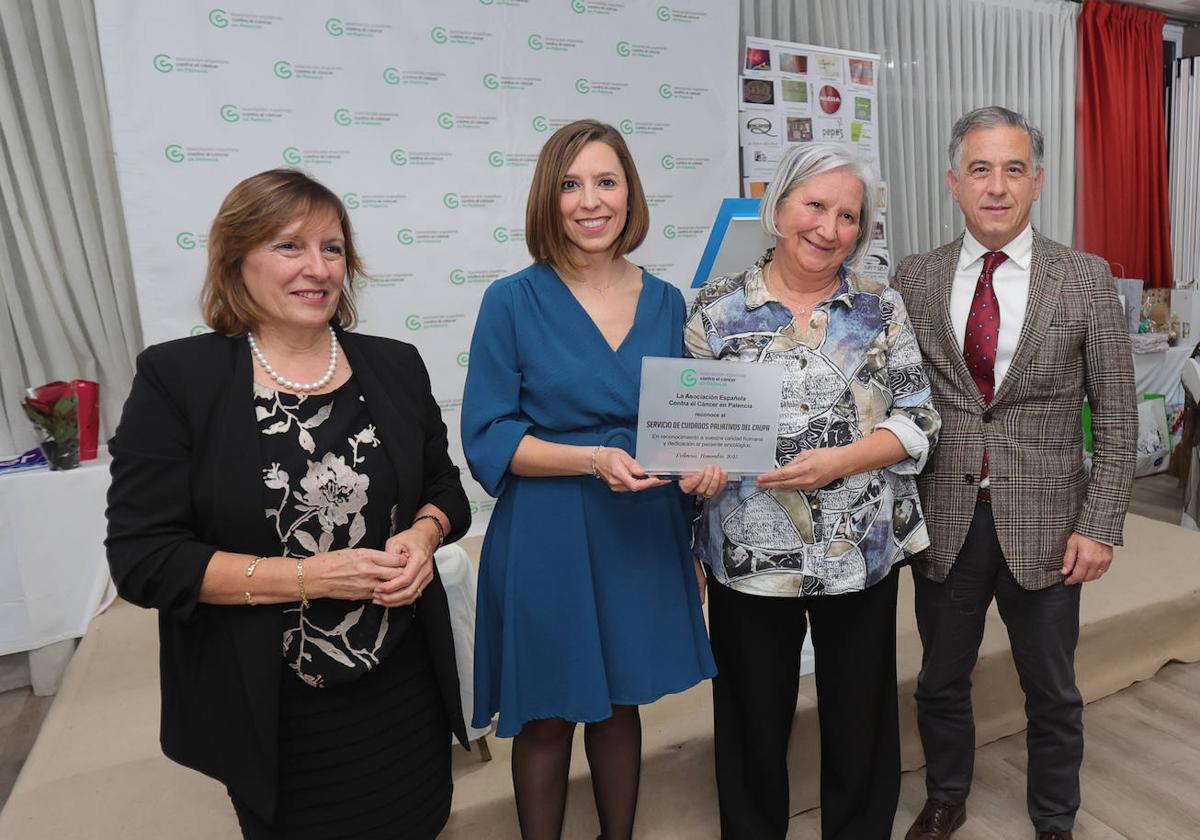 La presidenta de la asociación, Rosa Andrés, tras entregar el premio a Marisa Frutos y Marcela Córdoba, de la Unidad de Paliativos, en presencia del gerente del Caupa, José Jolín.