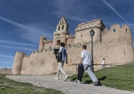 Varias personas suben por el acceso principal a la fortaleza de Turégano para realizar una visita guiada.
