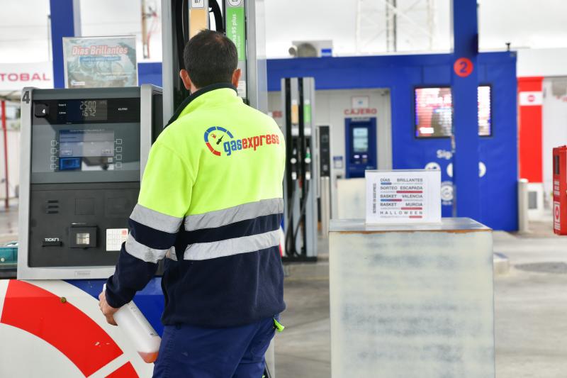 Un empleado prepara un surtidor en una estación de servicio.