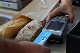 Un cliente paga una compra con su tarjeta de crédito en una panadería.