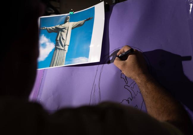 R. trabaja en su casa en la plantilla para la sombra del Cristo Redentor.