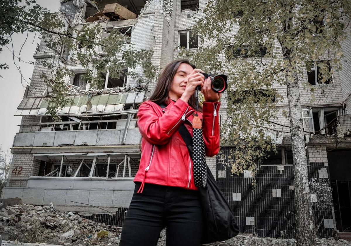 María Senovilla, con su cámara de fotos, delante de un edificio destruido en la guerra.