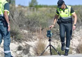 Agentes de la Guardia Civil colocan un equipo de radar en una carretera.