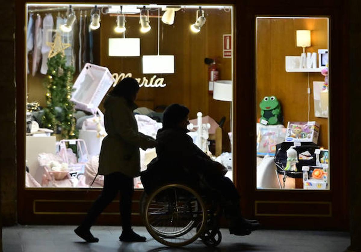 Dos personas pasan por delante de un escaparate iluminado en Valladolid.