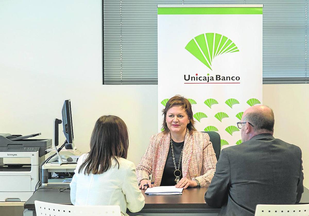 Una pareja se informa de los seguros agrarios de Unicaja Banco.