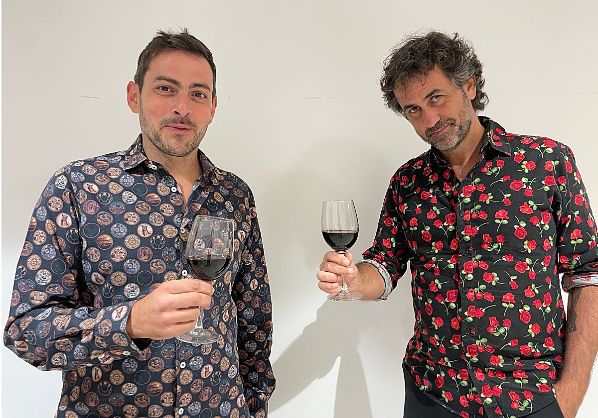 El dúo Fetén Fetén posa con una copa de vino.