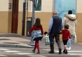 Un abuelo con sus nietos a la salida del colegio.