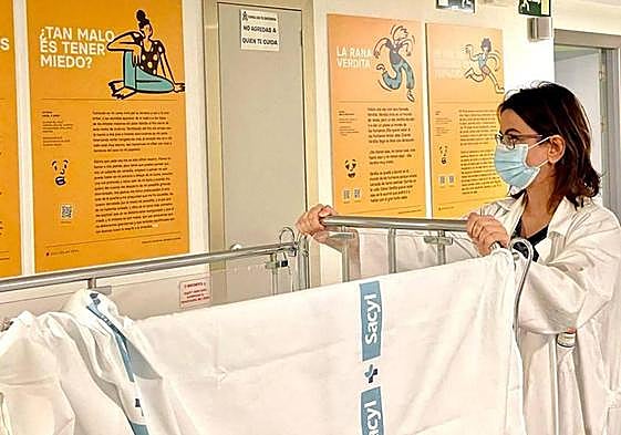 Una trabajadora de la Gerencia de Segovia contempla algunos de los paneles con cuentos de la exposición que acoge el Hospital General.