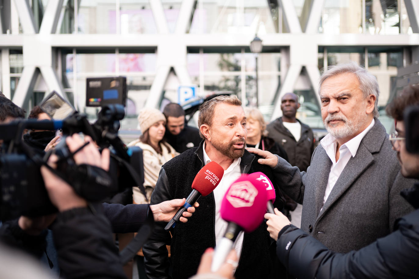 El presentador de televisión José Manuel Parada y el actor y cantante Enrique del Pozo atienden a los medios a su llegada a la capilla ardiente.