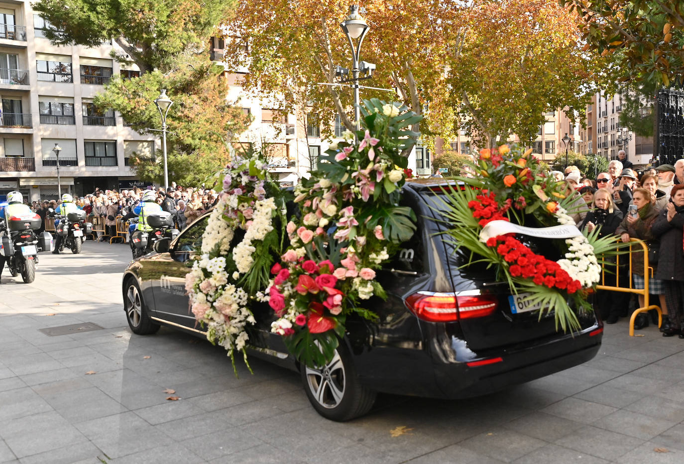 El coche fúnebre, lleno de flores, sale rumbo al cementerio.