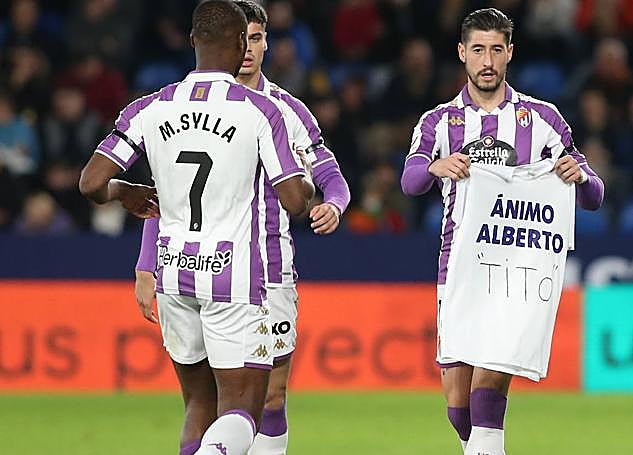 Escudero acerca a Sylla una camiseta con el nombre de Alberto.