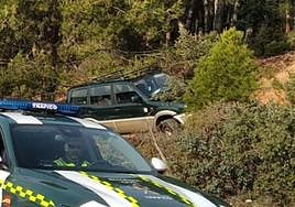 Lugar del accidente, con el todoterreno siniestrado a la derecha delante de una patrulla de la Guardia Civil.