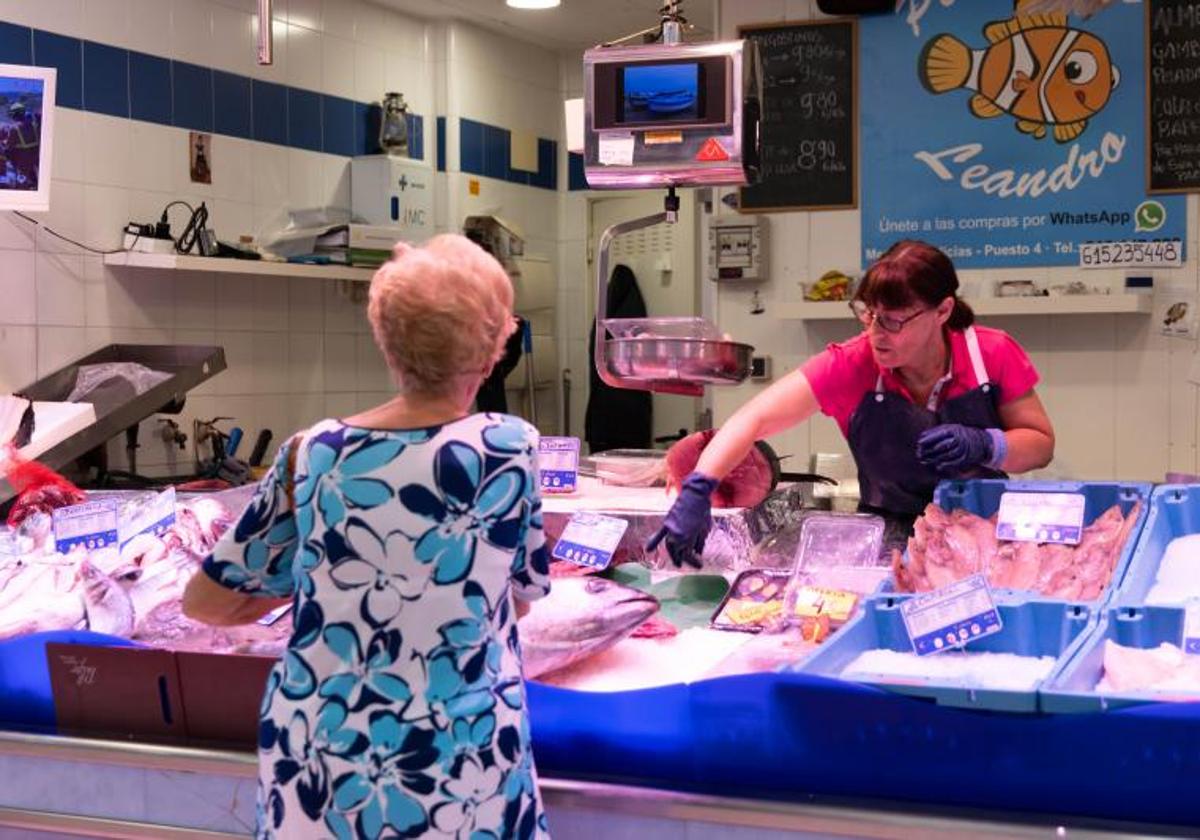 Una mujer compra en una pescadería del mercado de las Delicias.