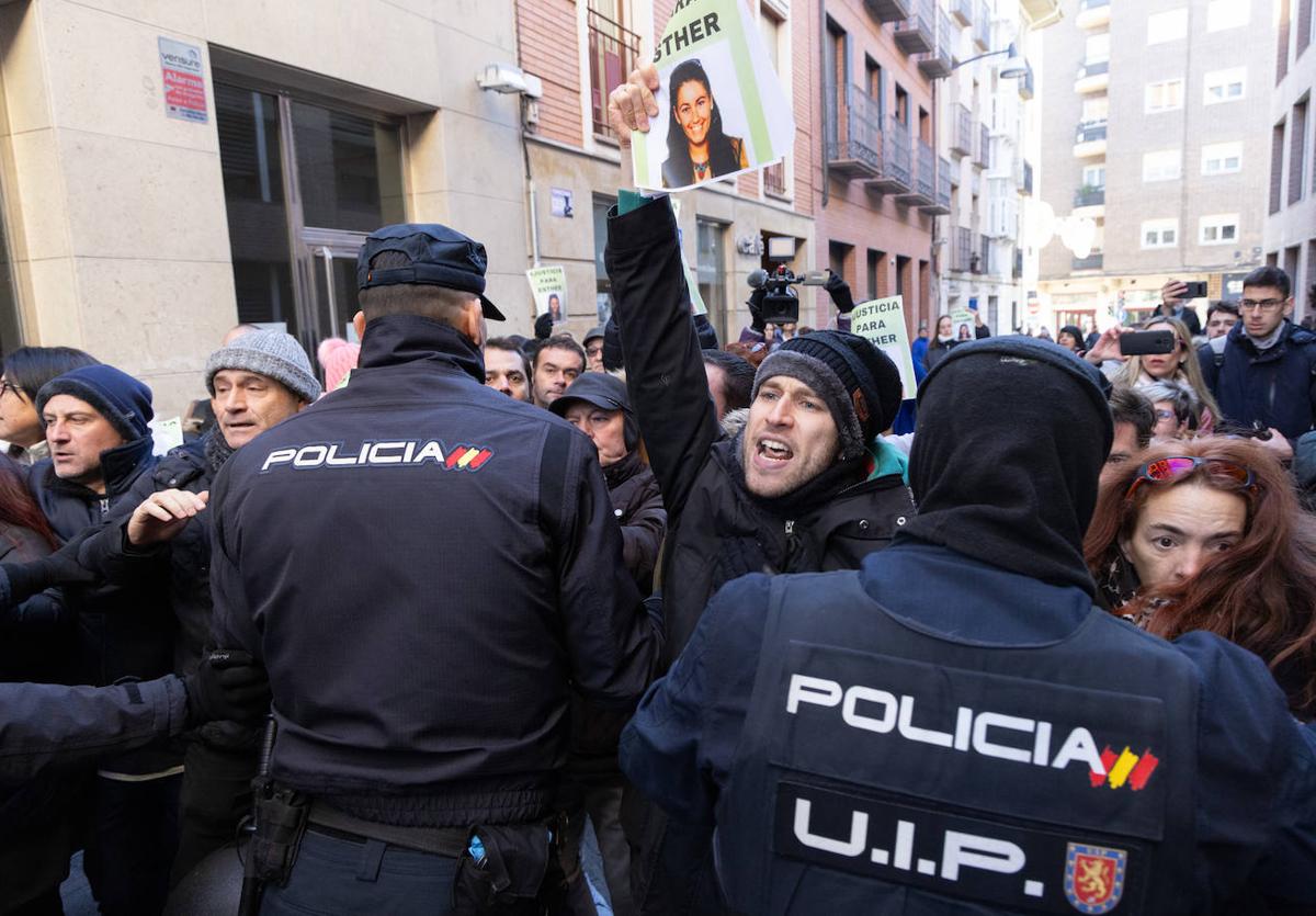 Agentes de policía contienen a los allegados de Esther López, que tratan de alcanzar el coche del investigado a la salida de los juzgados.