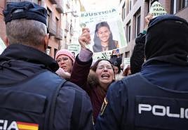 Una mujer exhibe un cartel con la imagen de Esther ante el cordon policial, este viernes en los juzgados.