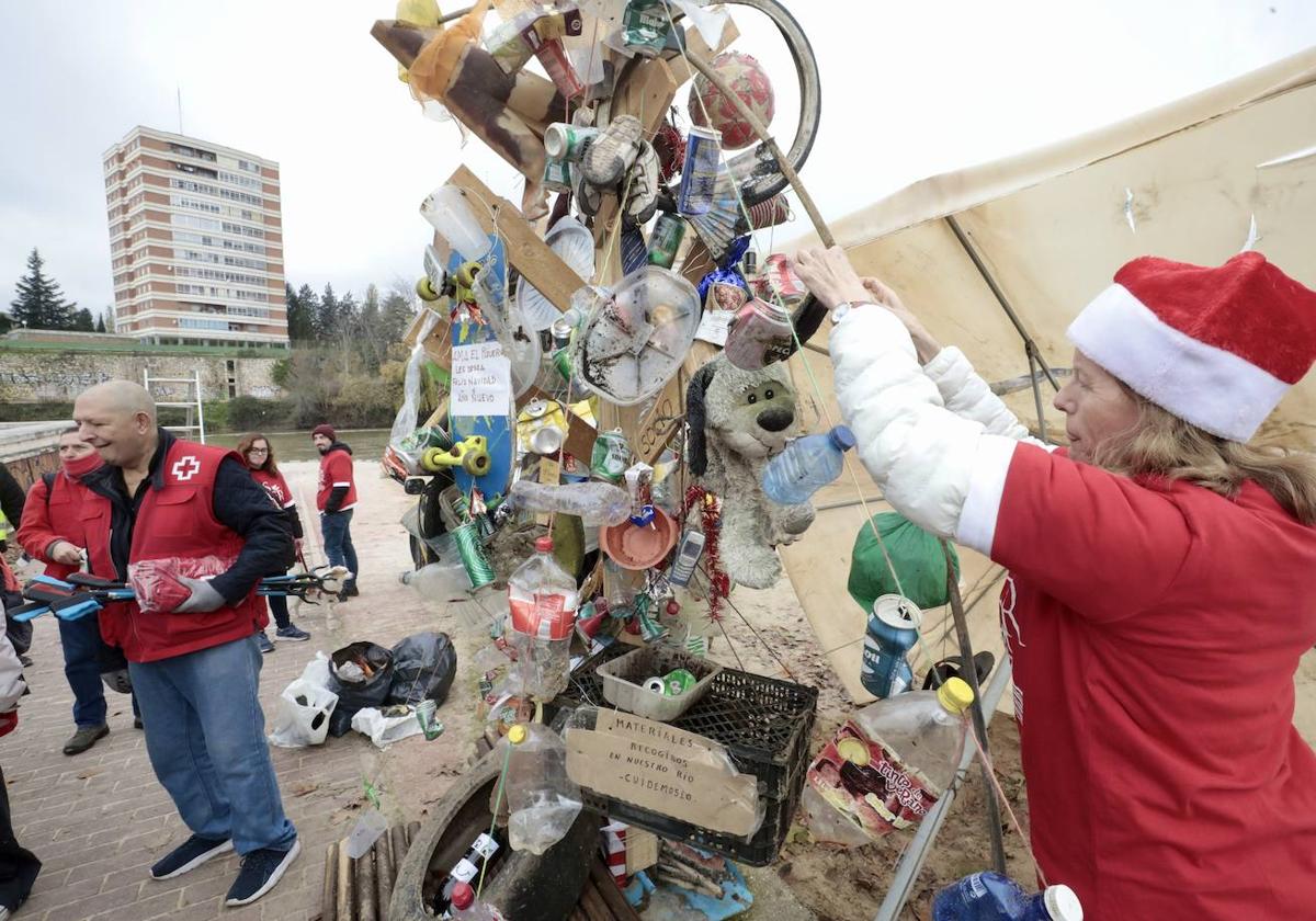 Una voluntaria de AMA El Pisuerga decora ayer el árbol.