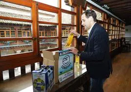 El presidente de la Diputación, Conrado Íscar, introduce una botella de aceite en una caja con destino el Banco de Alimentos de Valladolid.